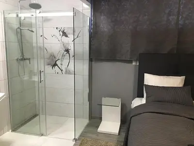 a bedroom with a glass shower stall next to a bed at Rooms & Apartments Banjac in Maribor
