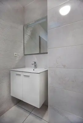a white bathroom with a sink and a mirror at Rooms & Apartments Banjac in Maribor