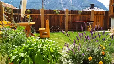 a garden with purple flowers and a wooden fence at Country house Dovje in Dovje