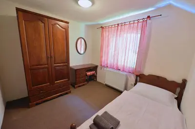 a bedroom with a bed and a cabinet and a window at Holiday Home Davča in Cerkno