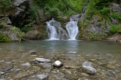 a waterfall in a river with rocks in the water at Holiday Home Davča in Cerkno