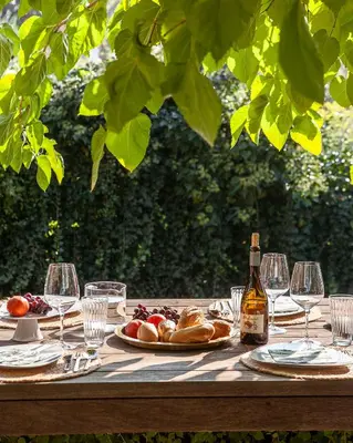 a wooden table with glasses and a bottle of wine at Villa Alma Vista in Dobrovo