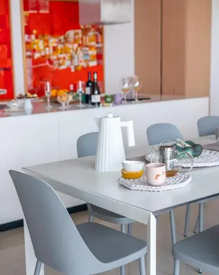 a white table with two chairs and a table with cups at Villa Alma Vista in Dobrovo