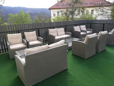 a group of chairs and tables on a patio at Life Hostel Slovenia in Radovljica