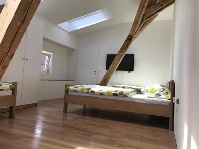 a bedroom with a bed and a tv on the wall at Life Hostel Slovenia in Radovljica