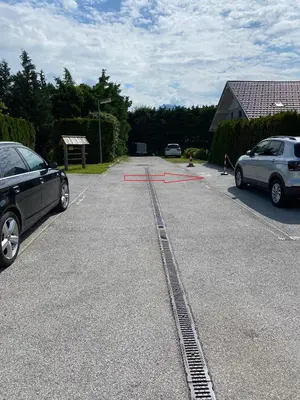 two cars parked in a parking lot with a track in the road at MTM apartment in Bled