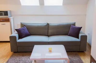 a living room with a couch and a coffee table at MTM apartment in Bled