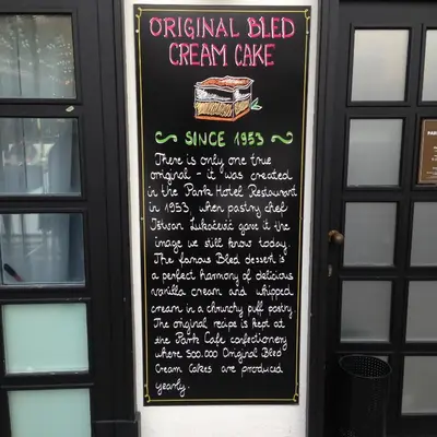a chalkboard sign on the door of a restaurant with a cake at MTM apartment in Bled