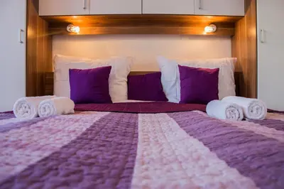 a bedroom with a large bed with purple and white pillows at MTM apartment in Bled