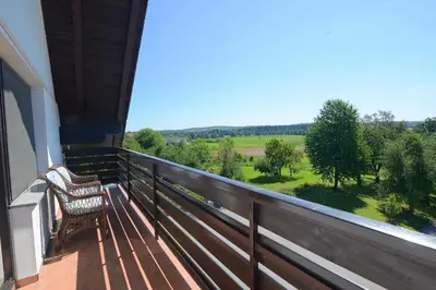 a balcony with two chairs and a view of a field at Župančičev hram in Dragatuš