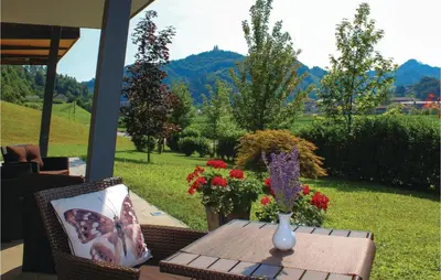 a patio table with a vase on it with flowers at Stunning Apartment In Lasko With Wifi in Laško