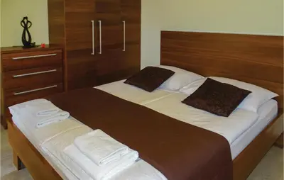 a bedroom with a large bed with a wooden headboard at Stunning Apartment In Lasko With Wifi in Laško