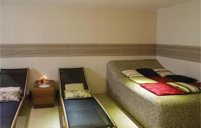a room with two beds and a table with a night stand at Stunning Apartment In Lasko With Wifi in Laško
