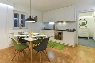 a kitchen with a table and chairs in a room at Strict city apartments in Ljubljana