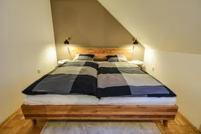 a bedroom with a large bed with a wooden headboard at Strict city apartments in Ljubljana