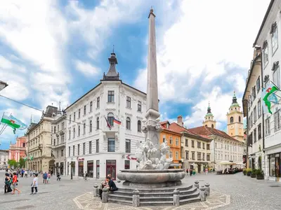 a statue in the middle of a city with buildings at Strict city apartments in Ljubljana