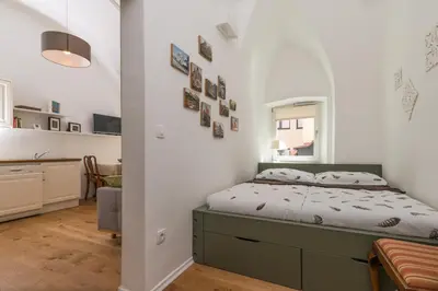a small bedroom with a bed and a kitchen at Barrio Alto in Ljubljana