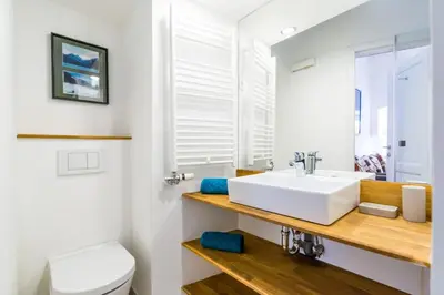 a bathroom with a white sink and a toilet at Barrio Alto in Ljubljana