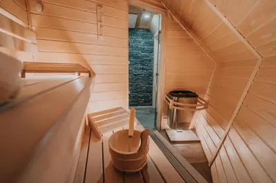 an interior view of a sauna with a tub at Koča Ojstrica - Velika planina in Stahovica