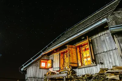 a house with stained glass windows on the side of it at Koča Ojstrica - Velika planina in Stahovica