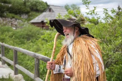 a man in a witch hat holding a broom at Koča Ojstrica - Velika planina in Stahovica