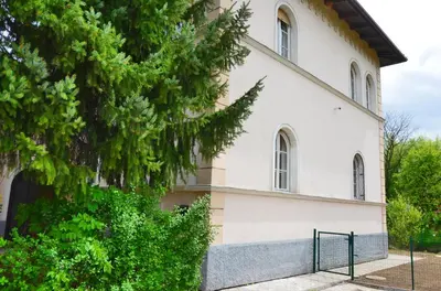 an old white building with trees in front of it at Apartment Soul in Ljubljana