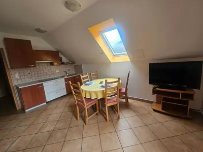 a kitchen and dining room with a table and a television at Apartmaji Mlinar in Kranjska Gora