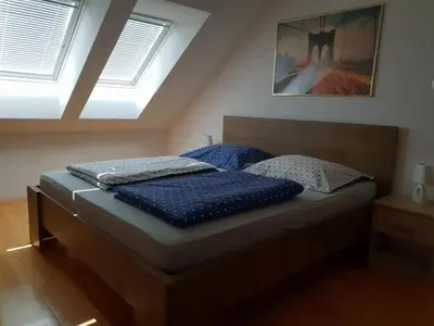 a bedroom with a bed with blue pillows on it at Apartment Beks in Postojna