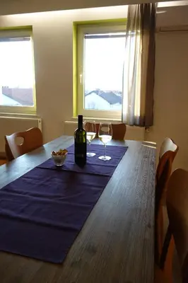 a table with a bottle of wine and two glasses at Apartment Beks in Postojna