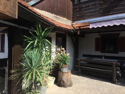 a porch of a house with potted plants and a bench at Gostišče Smuk in Križe
