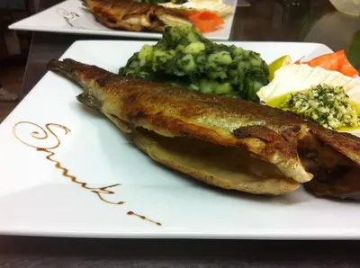 a plate of food with fish and broccoli on it at Gostišče Smuk in Križe