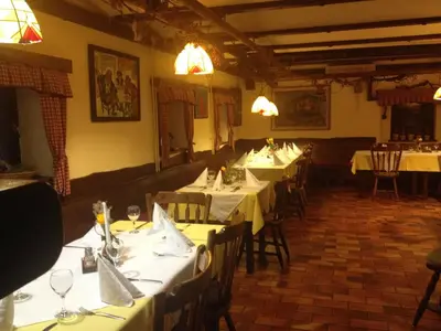 a dining room with tables and chairs with white table linen at Gostišče Smuk in Križe