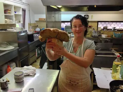 a woman holding a large teddy bear in a kitchen at Gostišče Smuk in Križe