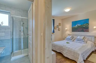 a bedroom with a king sized bed and a shower at Apartments ApArt Bled in Bled