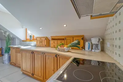 a kitchen with wooden cabinets and a counter top at Apartments ApArt Bled in Bled