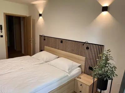 a bedroom with a white bed with two pillows at Prenočišča Mraz in Velenje