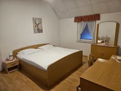 a small bedroom with a bed and a mirror at Prenočišča Mraz in Velenje