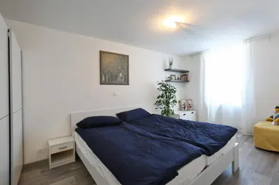 a bedroom with a bed with blue sheets and a window at CastleView in Ljubljana
