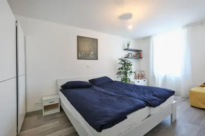 a bedroom with a bed with blue sheets and a window at CastleView in Ljubljana