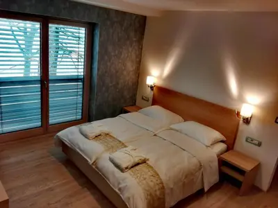 a bedroom with a large bed and a large window at Pan Prenočišča in Ptuj