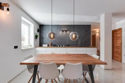 a dining room with a wooden table and white chairs at Apartments Julian Explore in Rateče