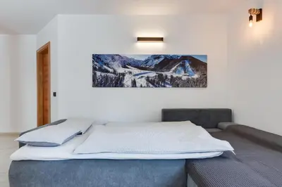 a bedroom with a bed with a picture on the wall at Apartments Julian Explore in Rateče