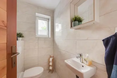 a bathroom with a sink and a toilet and a mirror at Apartments Julian Explore in Rateče