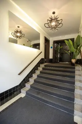 a set of stairs in a lobby with a chandelier at Urban Boutique Hotel Center in Ljubljana