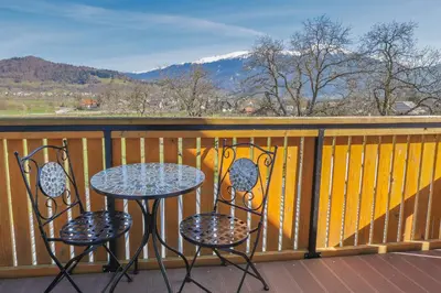 a table and two chairs on a balcony with mountains at Jazz Bled Guest House in Bled