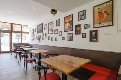 a row of tables in a restaurant with pictures on the wall at Jazz Bled Guest House in Bled
