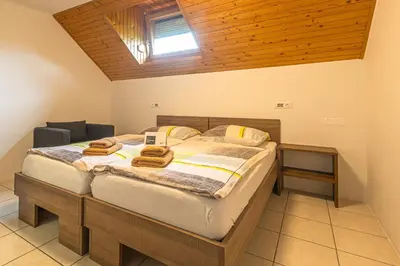 a bedroom with a large bed with towels on it at Jazz Bled Guest House in Bled