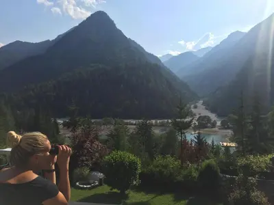 a woman taking a picture of a mountain valley at Outstanding Lake View. in Kranjska Gora