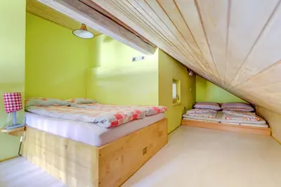 two beds in a room with green walls at Outstanding Lake View. in Kranjska Gora