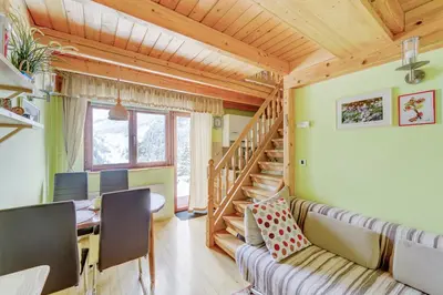 a living room with a couch and a table and a staircase at Outstanding Lake View. in Kranjska Gora